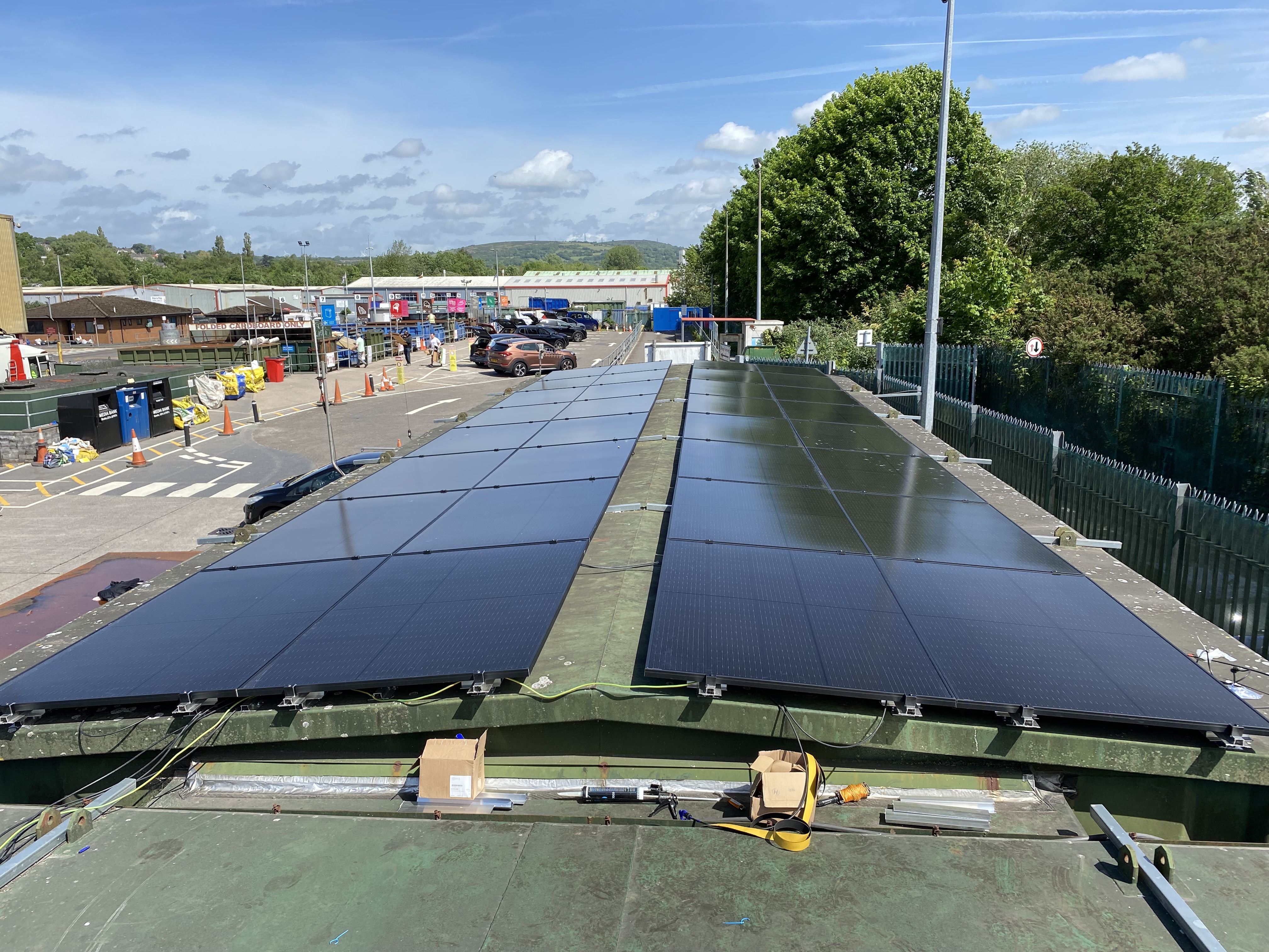 Recycling plant solar panels on modular container roof with trees behind